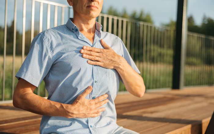 A person resting hands on chest and abdomen while breathing slowly
