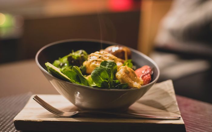 A bowl of fresh greens with grilled chicken