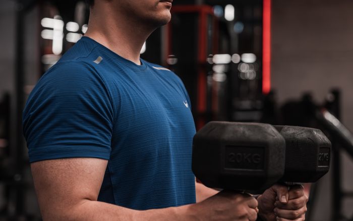 A person lifting dumbbells in a gym