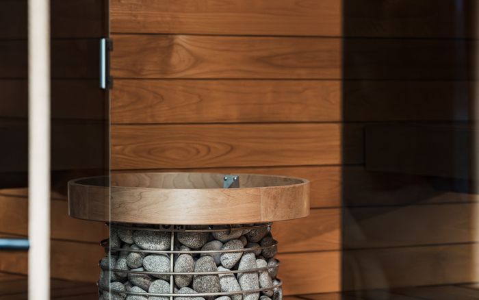 A contemporary sauna interior with a stone heater