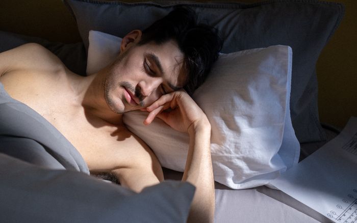 A man sleeping peacefully in a sunlit bedroom
