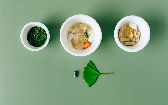 Ceramic bowls holding capsules and dried herbs