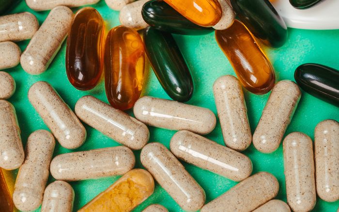 Close-up of assorted vitamins scattered on a green surface
