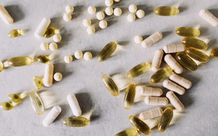 Vitamins and supplements arranged flat-lay on a marble background