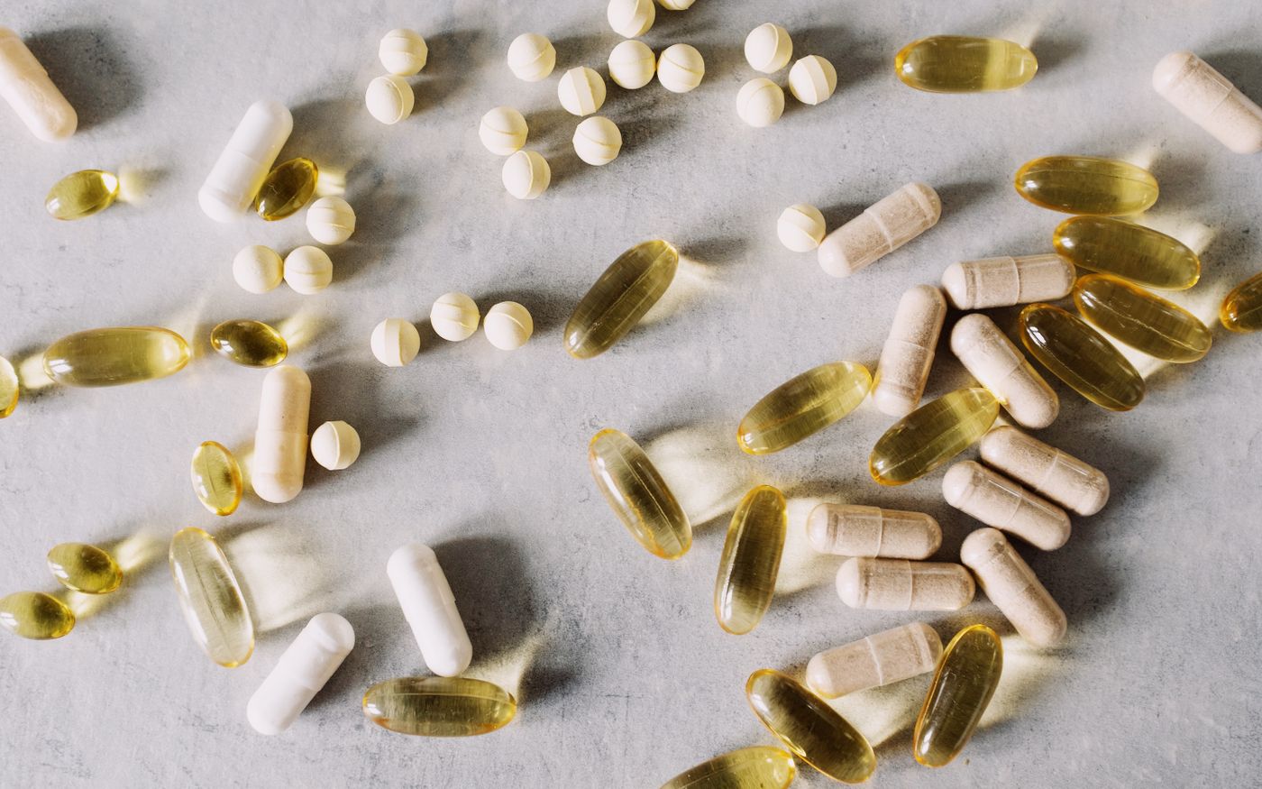 Vitamins and supplements arranged flat-lay on a marble background