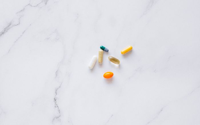An assortment of capsules arranged on a white marble surface