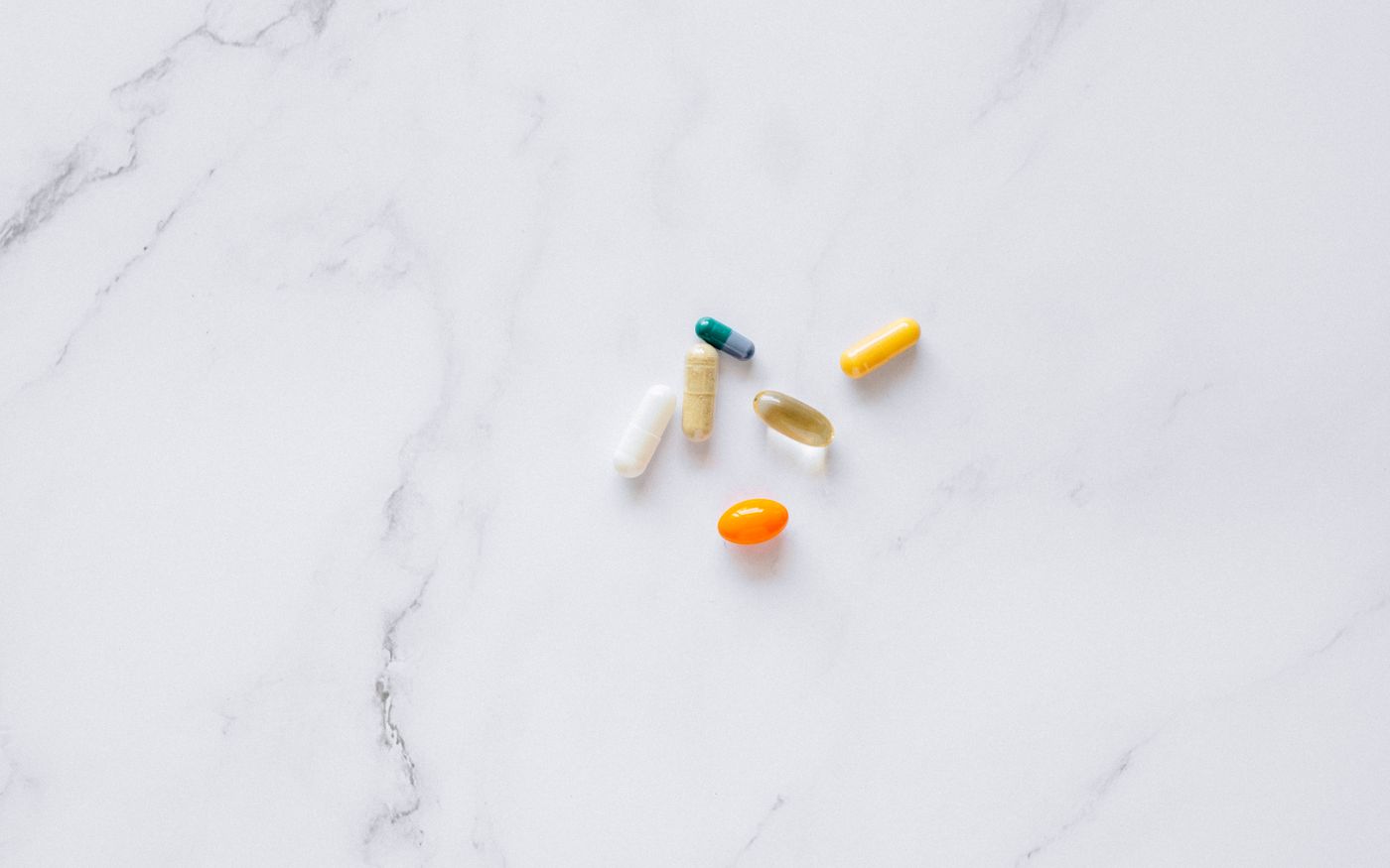 An assortment of capsules arranged on a white marble surface