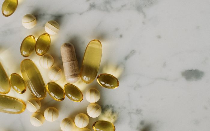 Capsules and tablets scattered across a marble surface