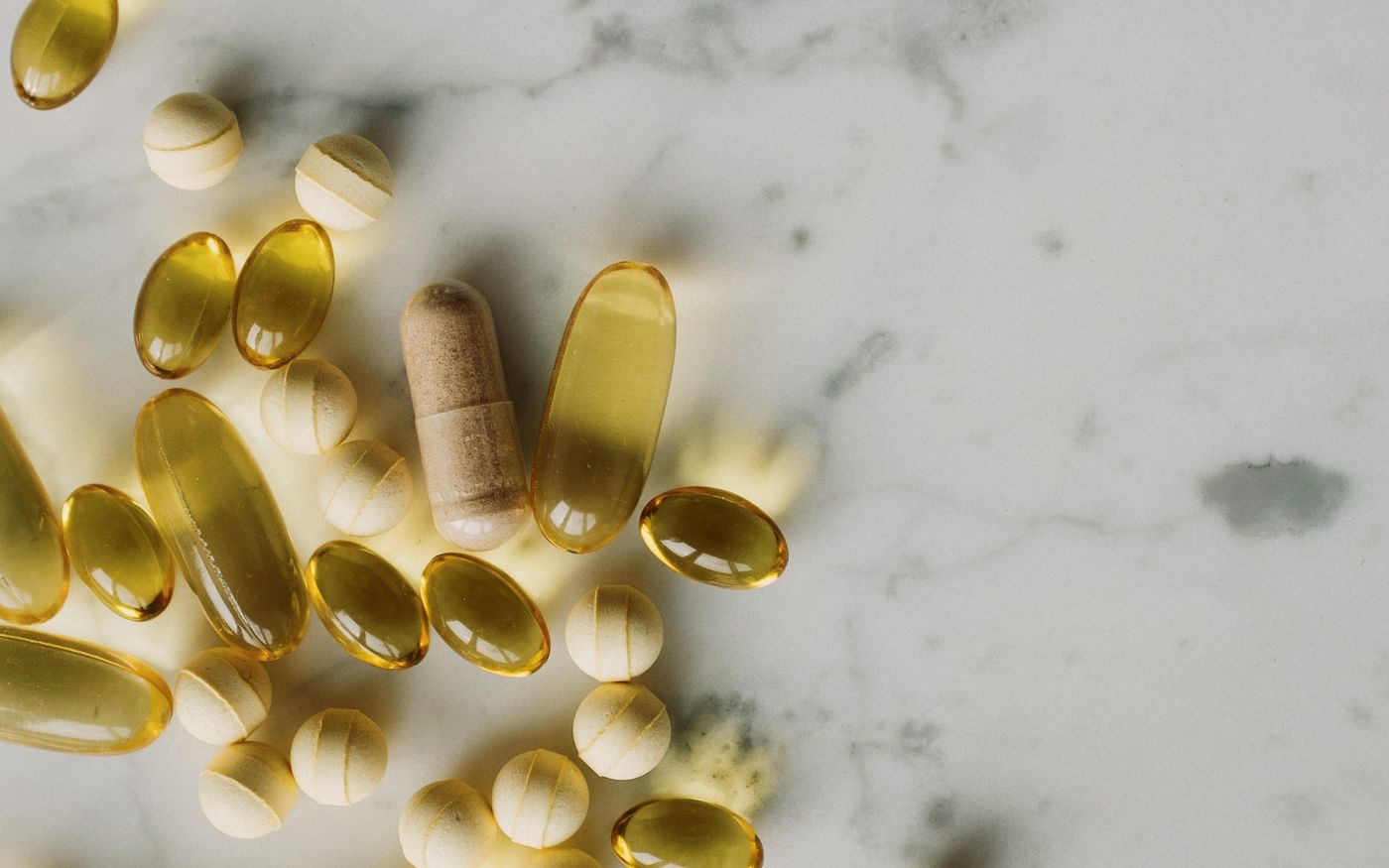 Capsules and tablets scattered across a marble surface