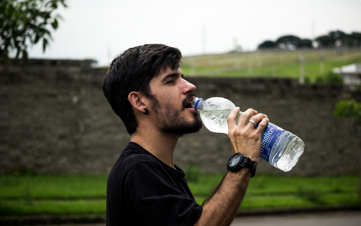 A person drinking water from a glass bottle